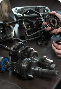 Female Mechanic Holding Spare Parts Car